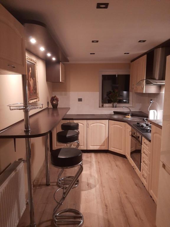 a kitchen with a counter and stools in it at Agroturystyka u Rolnika - Apartament in Stare Nowakowo