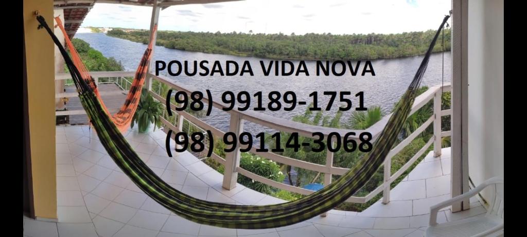 a hammock on a balcony with a view of the water at Pousada Vida Nova Barreirinhas MA in Barreirinhas