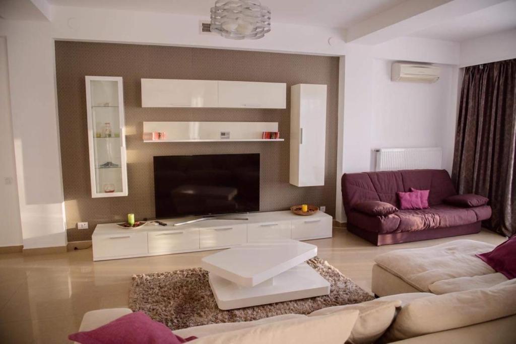 a living room with a couch and a tv at Sadara Sea Breeze in Mamaia Sat/Năvodari