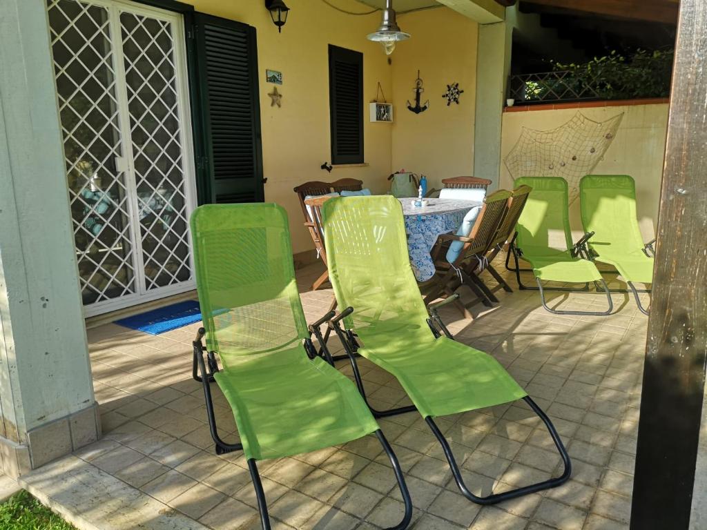 un grupo de sillas verdes sentadas en un patio en Cactus 2020, en Sabaudia