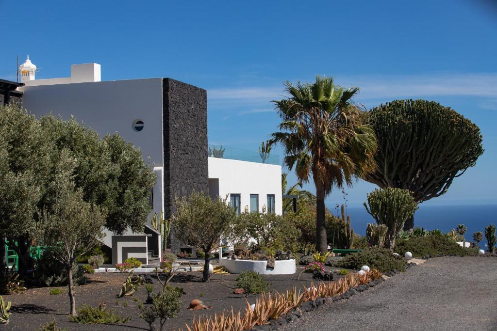 Mácherにある5 Suites Lanzaroteのヤシの木が目の前に広がる白い建物