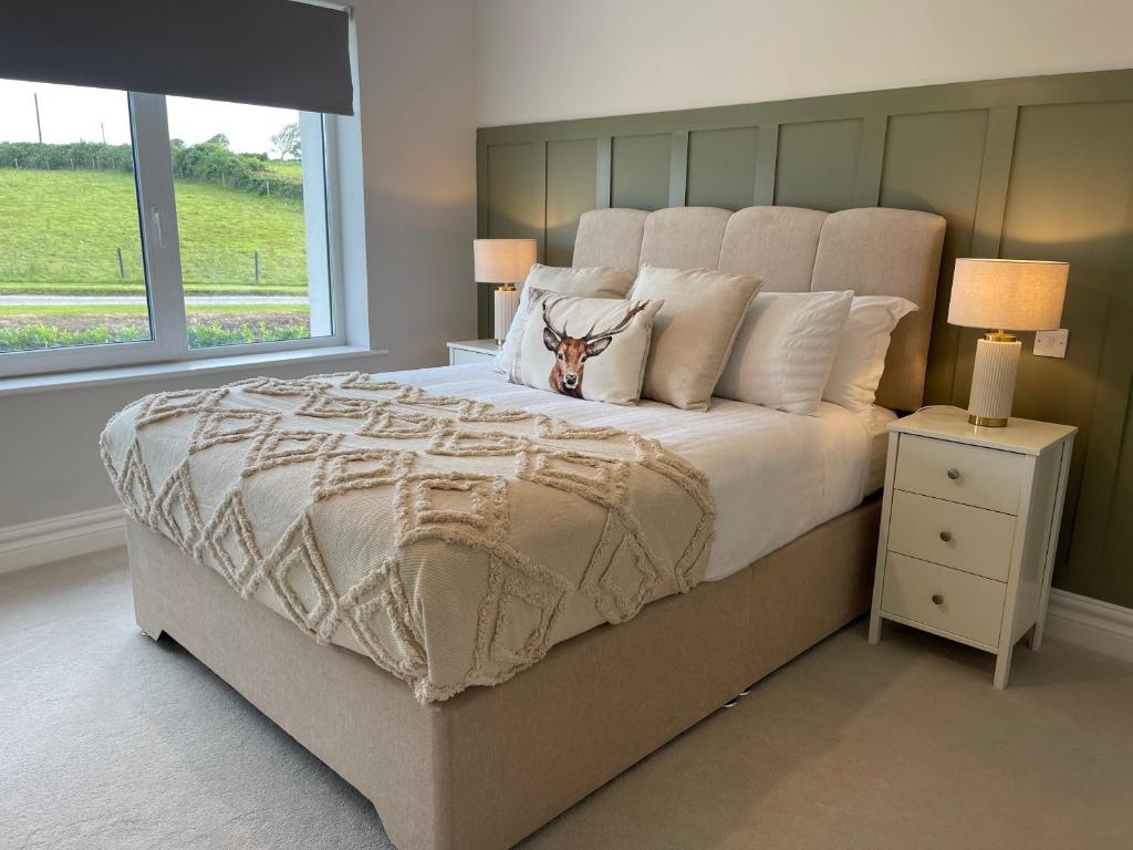 a bedroom with a large bed and a window at Country View House in Milltown