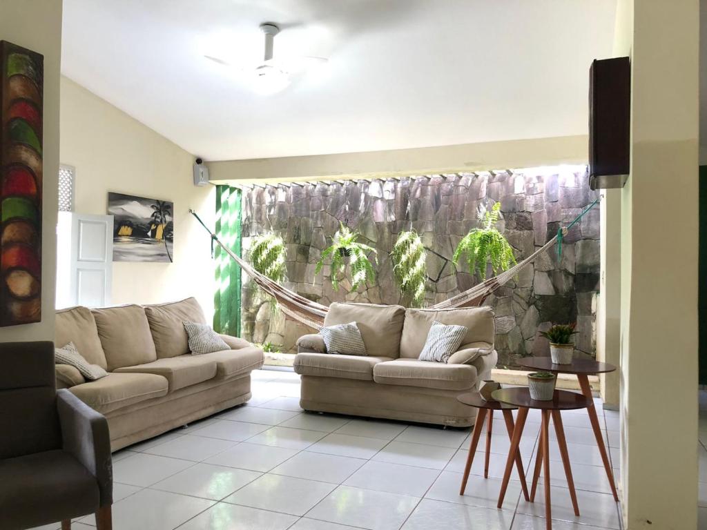 a living room with two couches in front of a window at Casa ampla e aconchegante no coração de Ponta Negra in Natal