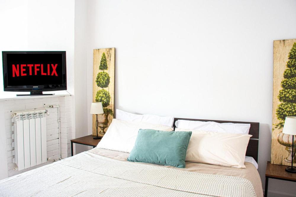 een slaapkamer met een bed en een tv aan de muur bij [Lake Maggiore Apt] ✦ Relax accanto alla spiaggia in Lisanza