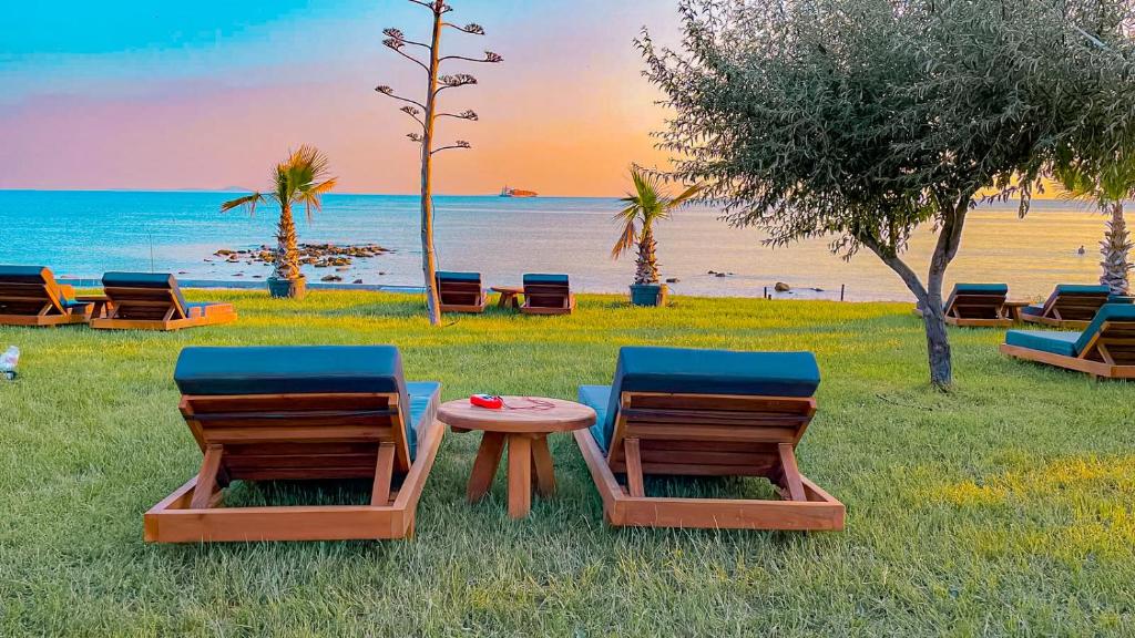 The Kirte Hotel V Beach : مجموعة من الكراسي وطاولة على الشاطئ