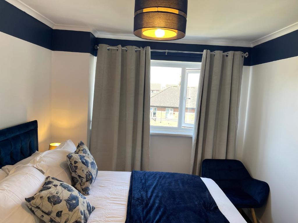 een slaapkamer met een bed en een raam bij Stylish 3 bed house, private parking, garden and conservatory in Sheffield