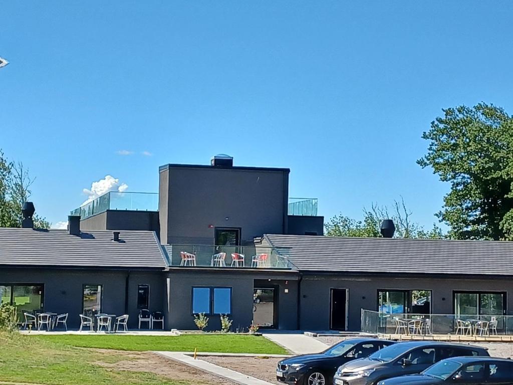 un bâtiment avec des voitures garées devant lui dans l'établissement Hotell Solstickan, à Mellbystrand