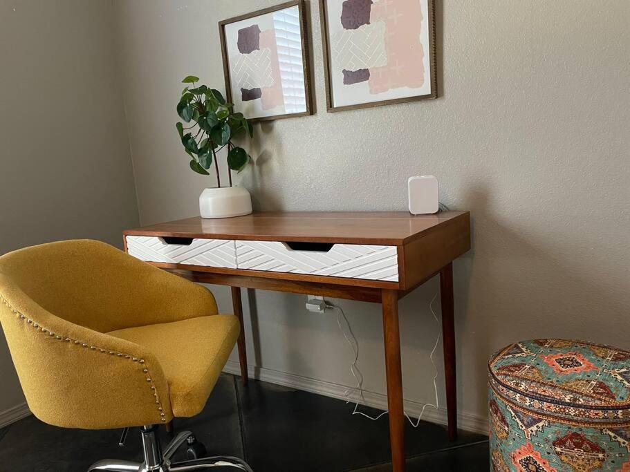 a desk with a chair and a plant on a wall at 10 mins KING Smart TV Garage W/D in Amarillo