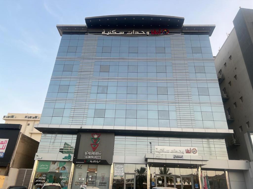 a tall glass building with a sign on it at Anfa furnished apartments in Jeddah