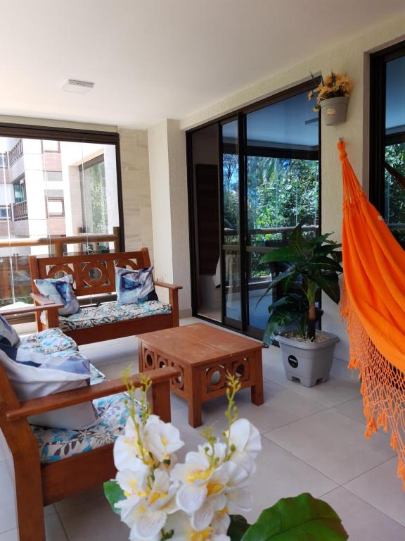 a living room with chairs and tables and windows at Apartamento Waiwai Cumbuco in Cumbuco