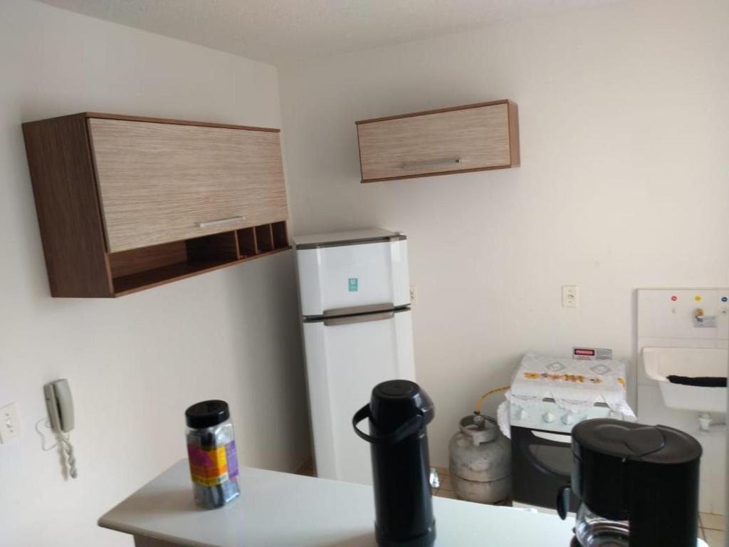 a kitchen with a white refrigerator and a counter top at Apto Solar do Coqueiro in Campos dos Goytacazes
