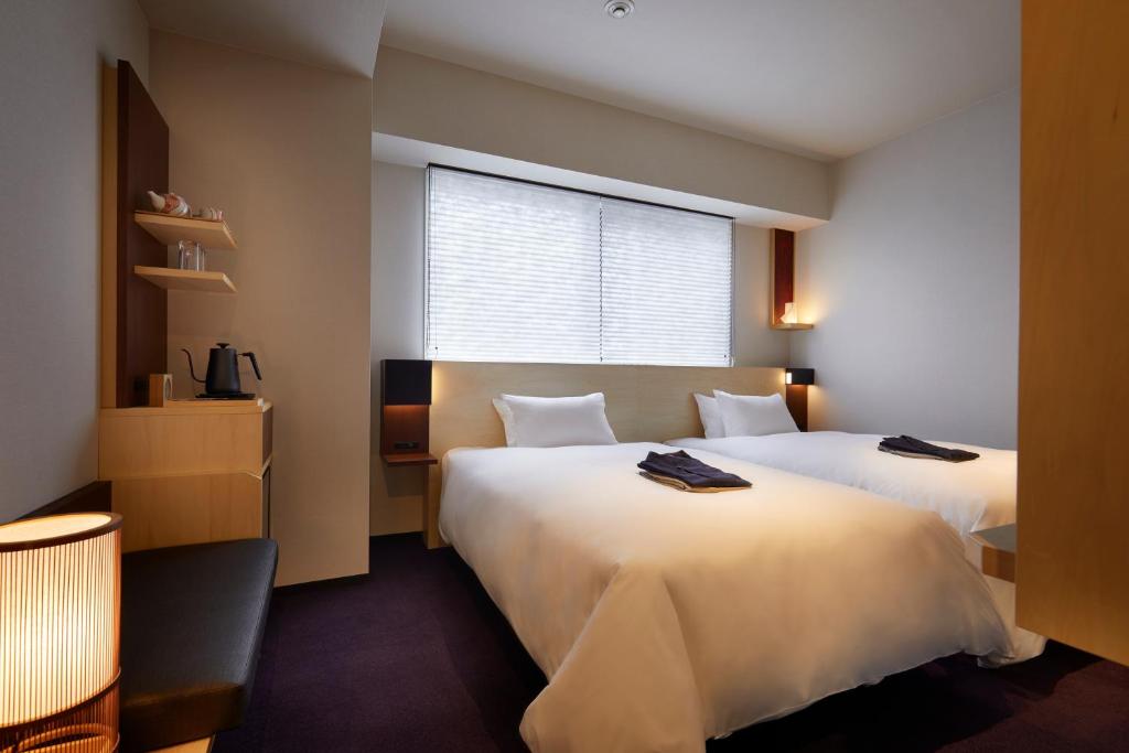 Postel nebo postele na pokoji v ubytování HOTEL AMANEK Kanazawa