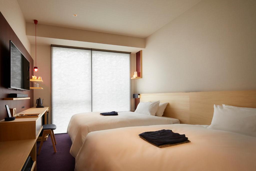 Postel nebo postele na pokoji v ubytování HOTEL AMANEK Kanazawa