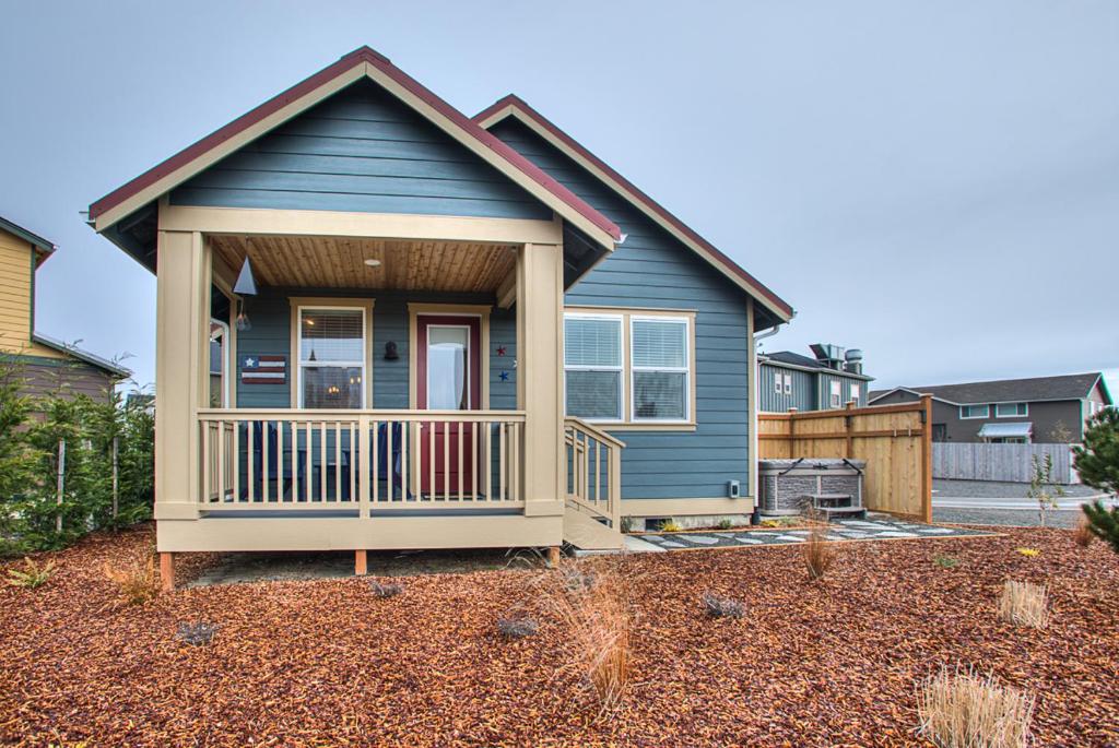 a small blue house with a porch in a yard at Sea Stars Stripes Beach Cottage in Ocean Shores