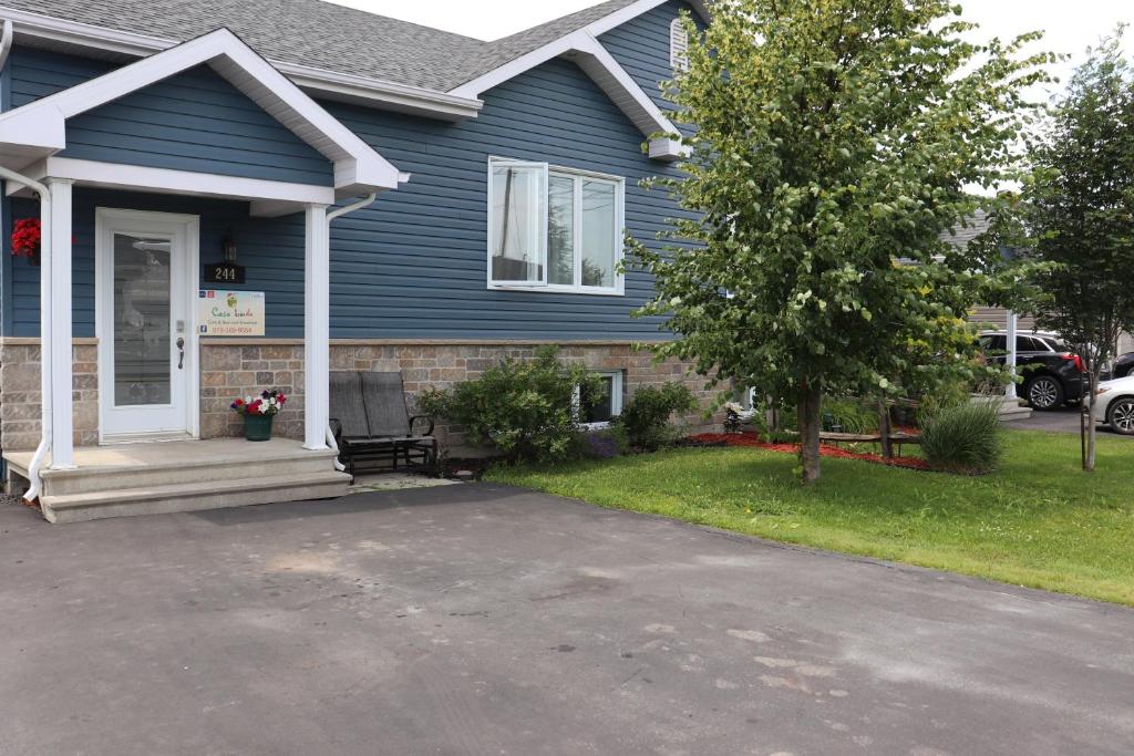 a blue house with a driveway in front of it at Casa Linda Victoriaville in Princeville