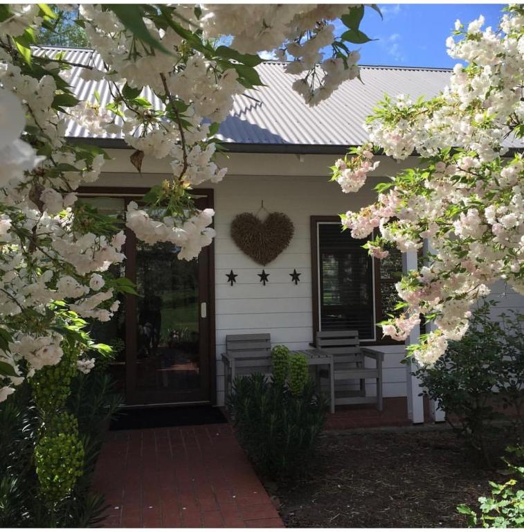 a white house with a heart on the front door at King River Cottage in Moyhu