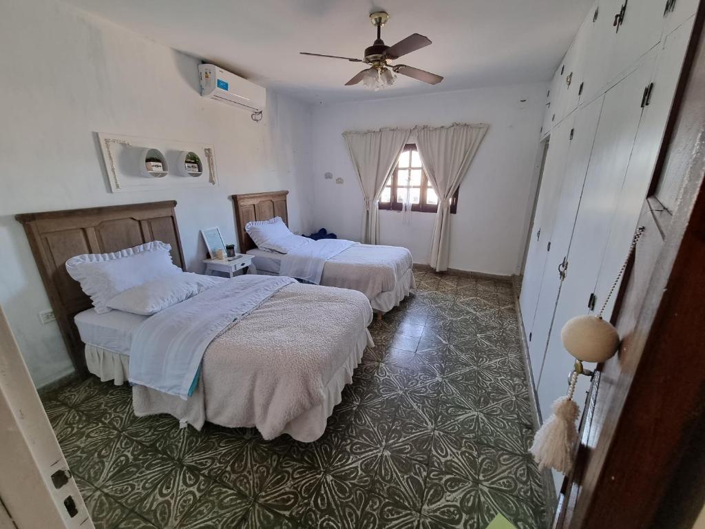 um quarto com 2 camas e uma ventoinha de tecto em White House - Hospedaje con Desayuno em La Rioja