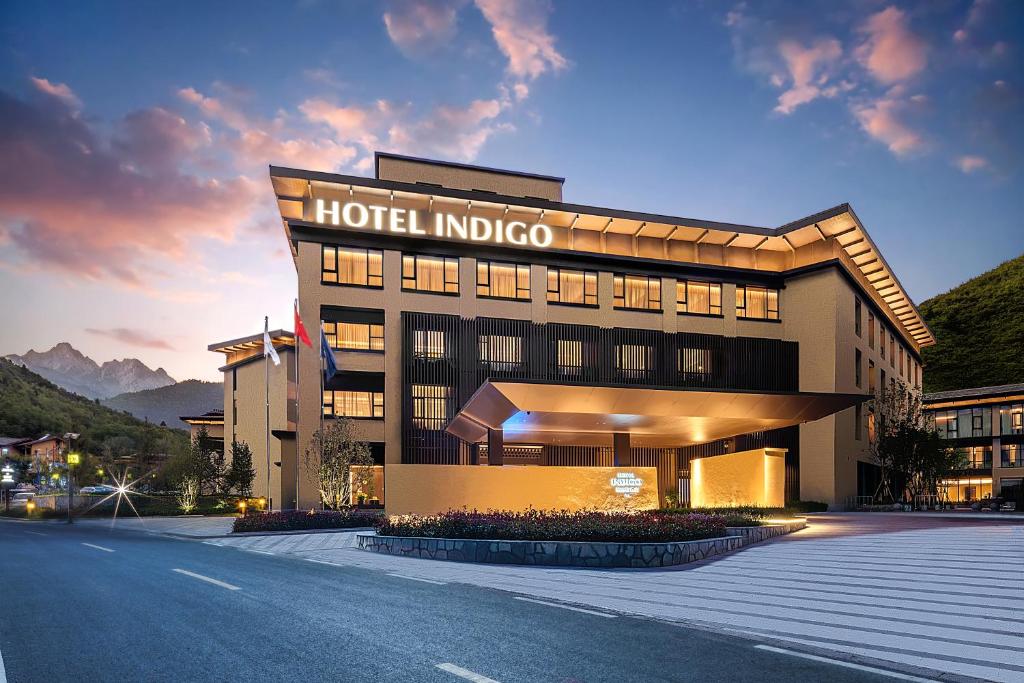 un hotel edificio indigo con una carretera delante de él en Hotel Indigo Jiuzhai, an IHG Hotel, en Jiuzhaigou