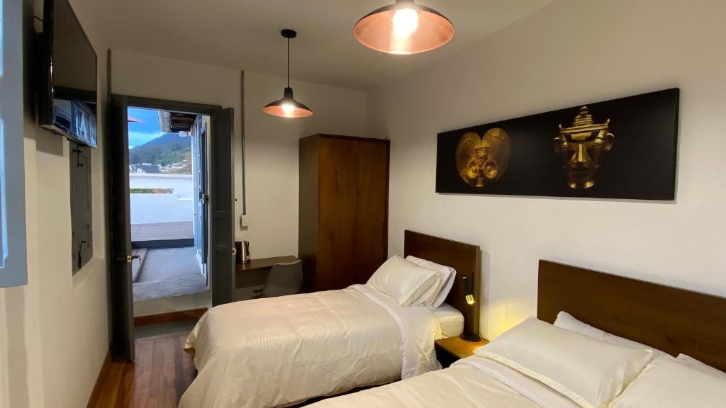 um quarto de hotel com duas camas e uma janela em REPUBLICANA CASA HOSTAL - HABITACIÓN 6 CALIMA em Bogotá
