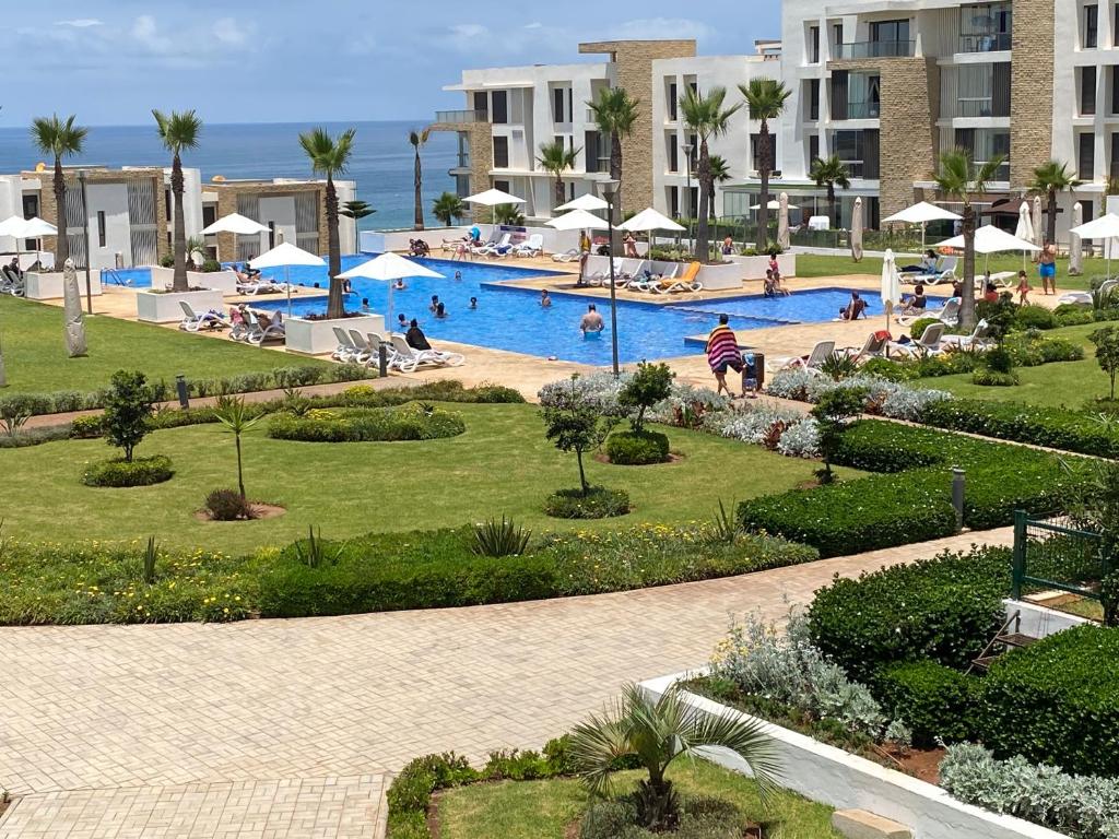 a resort with a swimming pool with people in it at Prestigia plage des nations in Sale