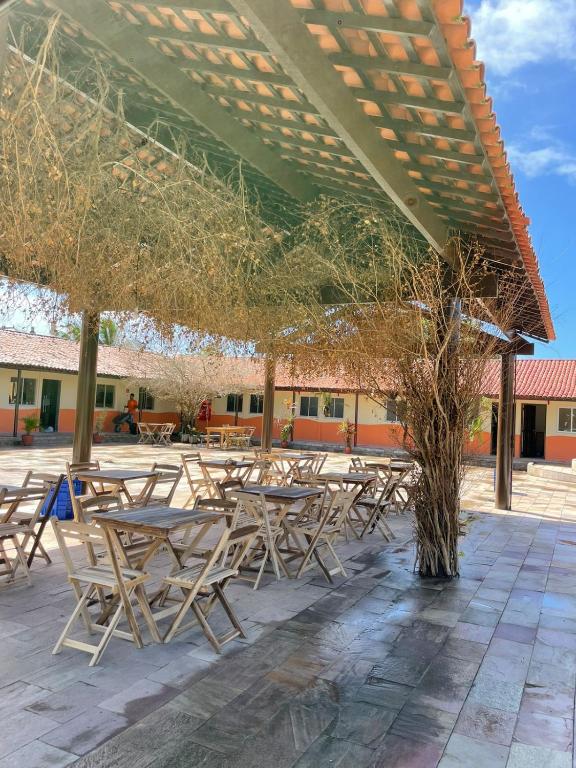 a group of tables and chairs under a roof at Arena Carneiros Hotel by AFT in Tamandaré