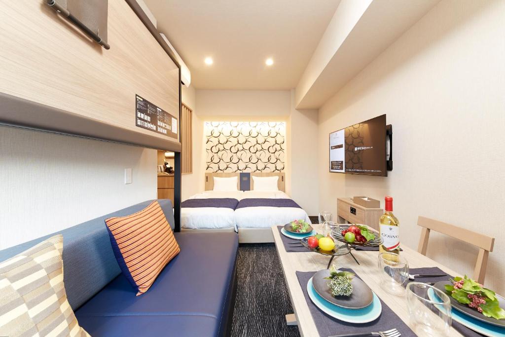una camera d'albergo con un letto e un tavolo con cibo sopra di Minn Kasai a Tokyo
