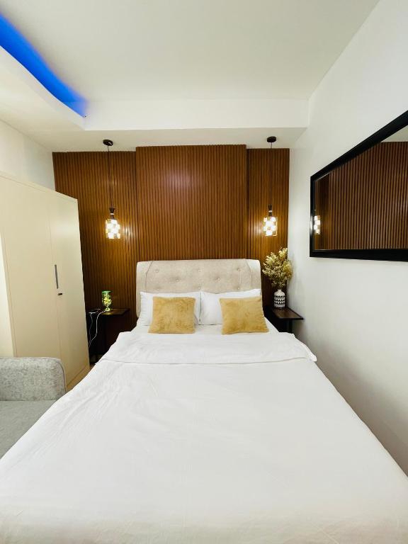 a bedroom with a large white bed with yellow pillows at Lou- Mesaverte Residences in Cagayan de Oro