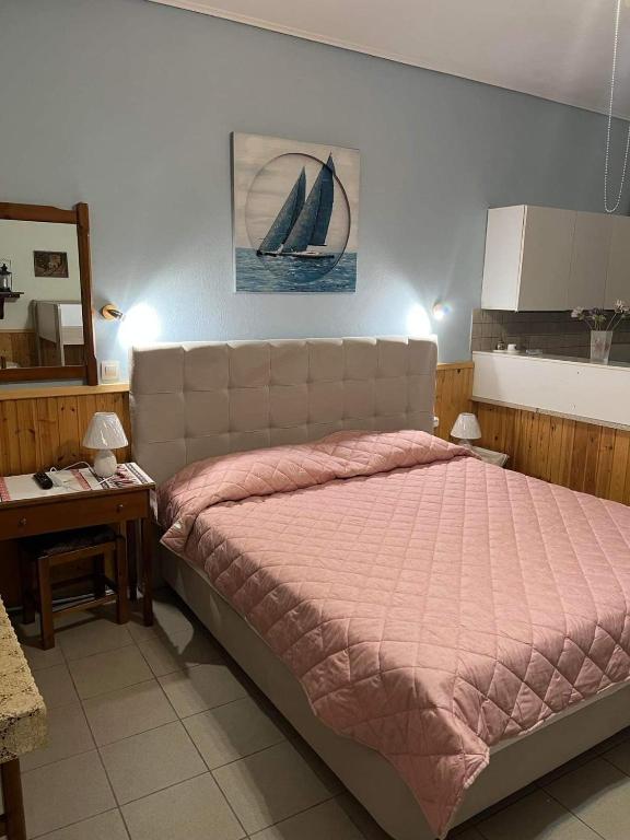 a bedroom with a bed and a sailboat on the wall at AFISSOS-DREAM 3STUDIOS in Afissos