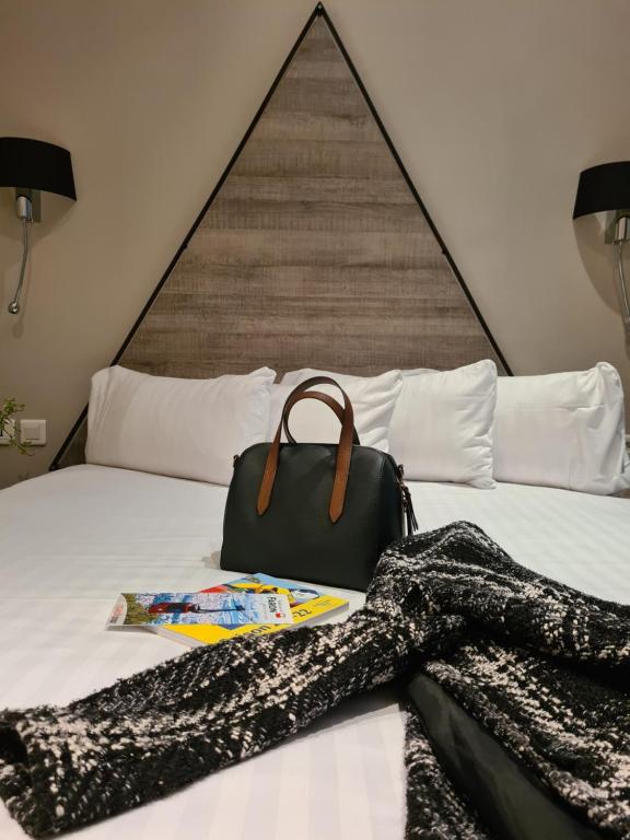 a purse sitting on top of a bed at Hôtel Amirauté in Toulon