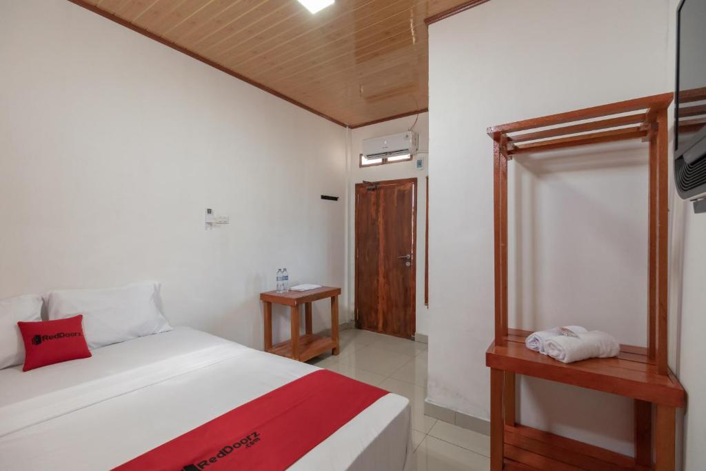 a bedroom with a bed and a window and a television at RedDoorz Syariah near Jakabaring Sport City Palembang in Kertapati