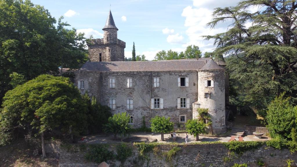 Saint-Étienne-Vallée-FrançaiseにあるLe Château de Cambiaireの塔のある古い石造りの建物