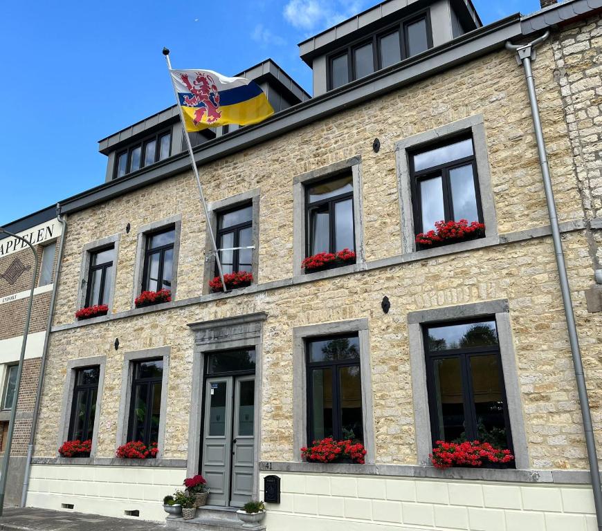 un drapeau battant devant un bâtiment en briques dans l'établissement Eigenheimer B&B, à Simpelveld