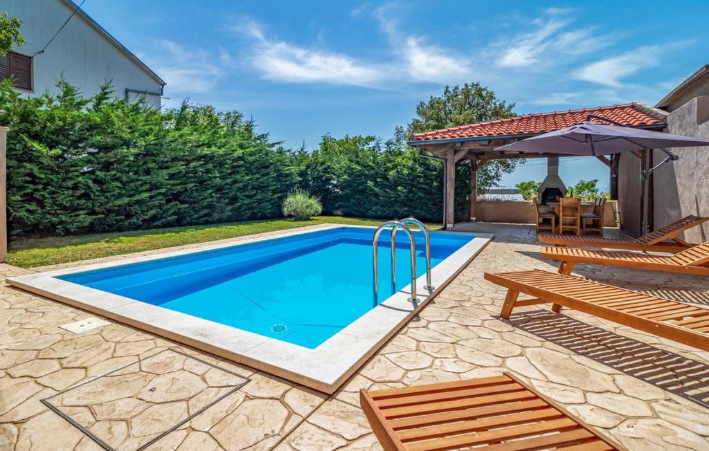 a swimming pool with two chairs and an umbrella at House Lavander in Šmrika