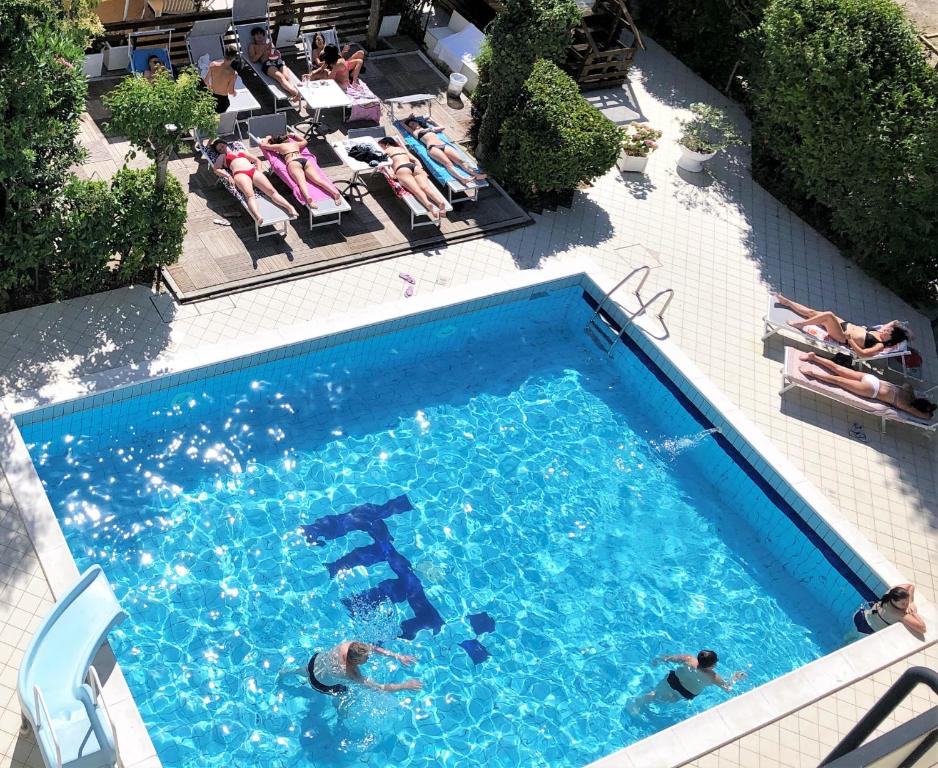 una vista sul soffitto di una piscina con sedie a sdraio di Hotel Marzia con Piscina a Riccione