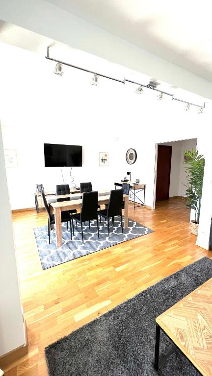 sala de estar con mesa, sillas y TV en Superbe appartement en centre-ville, 20min de Paris, 5 min d&#39;Enghien, en Saint-Gratien