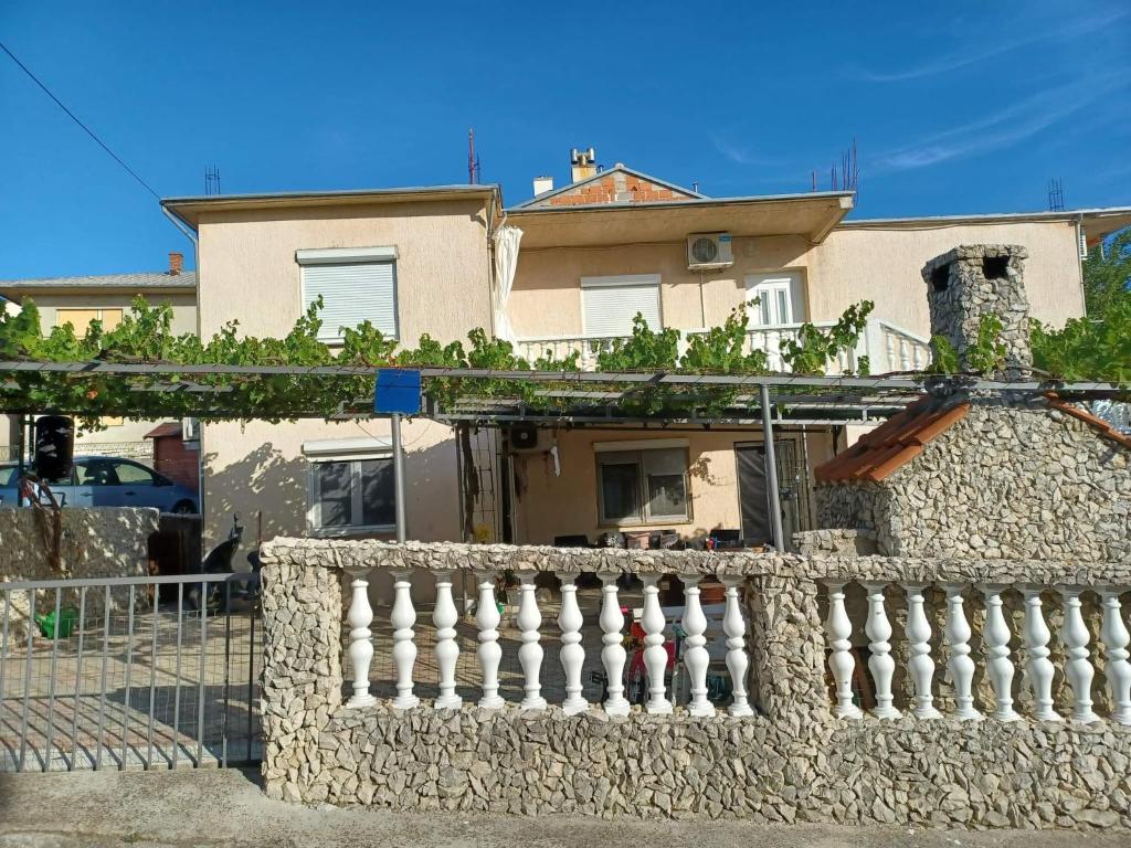 a stone fence in front of a house at Apartments Jamice in Novi Vinodolski