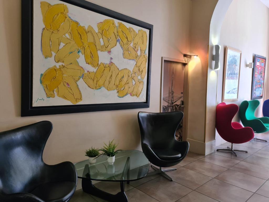 a waiting room with chairs and a glass table at Hôtel Amirauté in Toulon