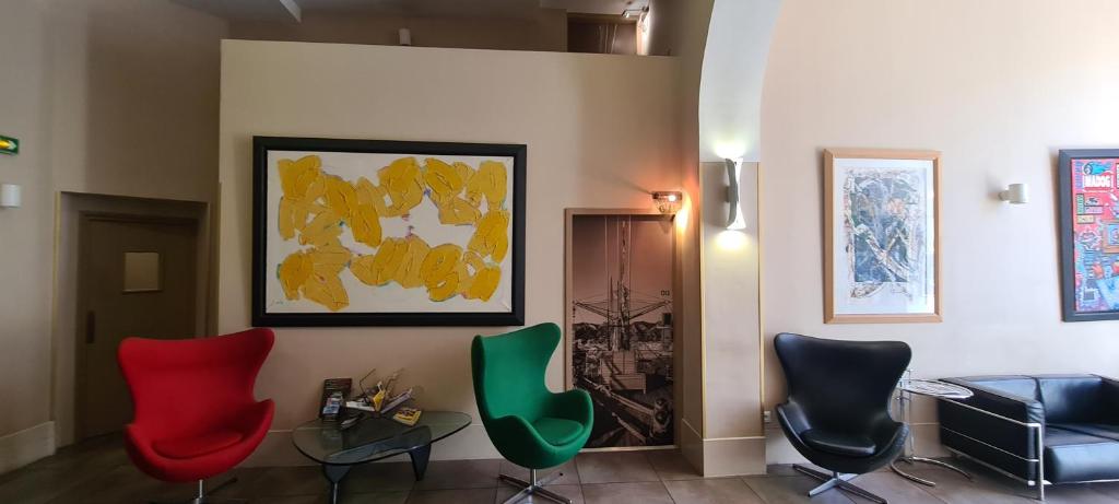a room with chairs and a table and a painting at Hôtel Amirauté in Toulon