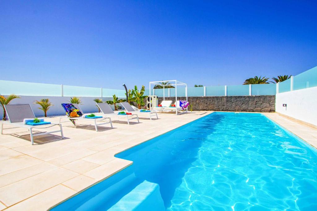 a swimming pool with lounge chairs and a swimming pool at Villa Balandra in Playa Blanca
