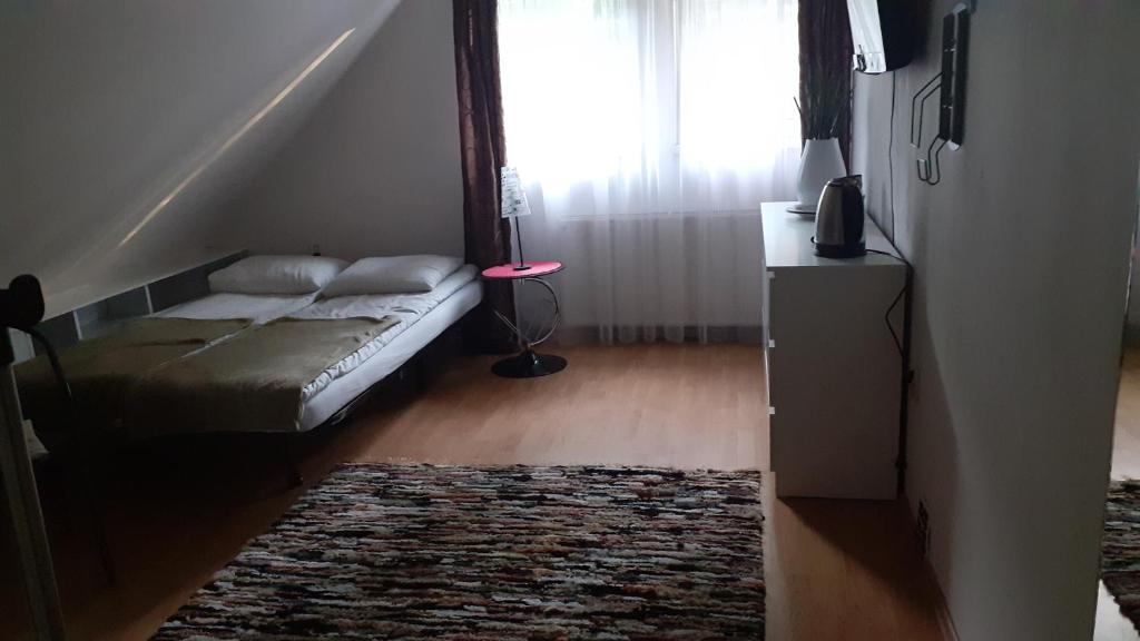 a bedroom with a bed and a window with a rug at Pokoje przy Parku in Gdańsk