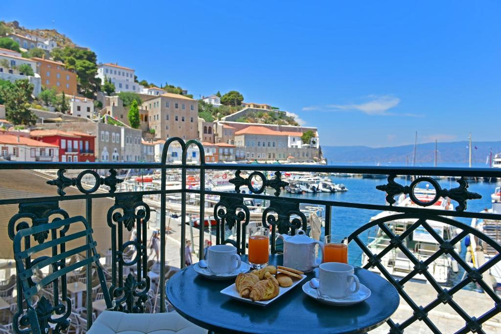 una mesa azul con comida en la parte superior de un balcón en Hotel Sophia, en Hydra