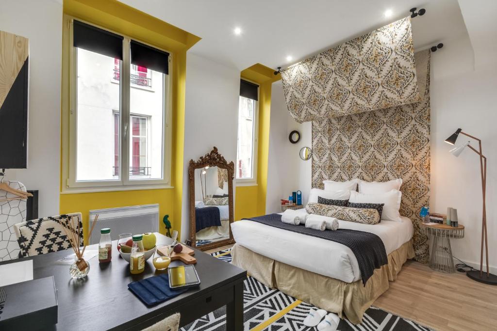 パリにあるSweet Inn - Aboukir IIのベッドとデスクが備わるホテルルームです。