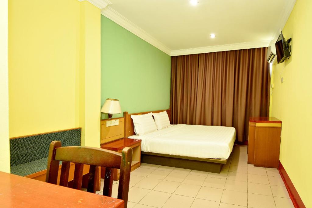 a hotel room with a bed and a table at Mandarin Inn by Glex in Mukah