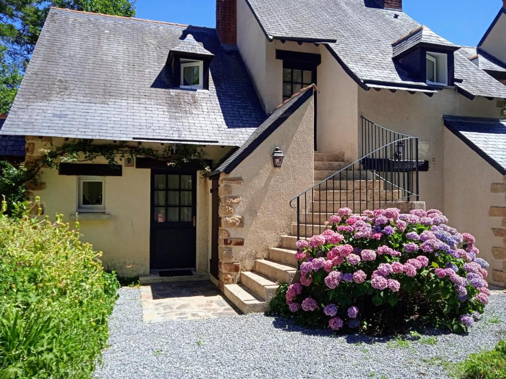 uma casa com um ramo de flores à frente dela em Cottage sur le Domaine du golf de la Bretesche em Missillac