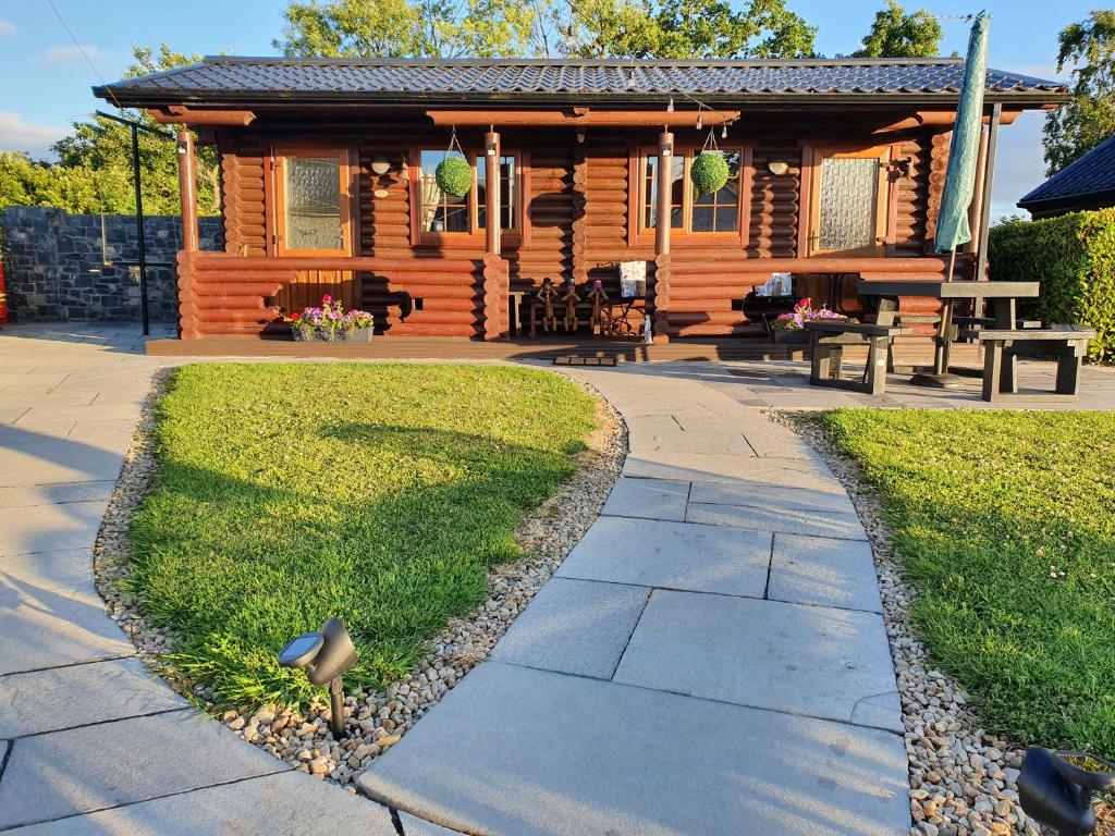 um pássaro parado em frente a uma cabana de madeira em Cosy Countryside Log Cabin em Kilkenny