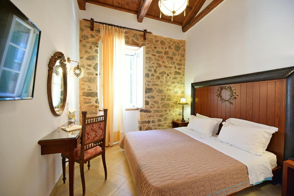 una camera con letto, scrivania e finestra di Hotel Sophia a Hydra