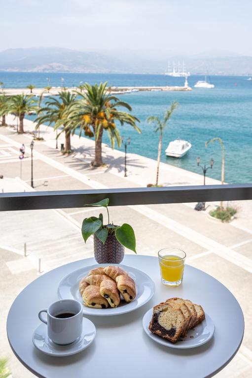 a table with two plates of pastries and a cup of coffee at Agamemnon Hotel in Nafplio