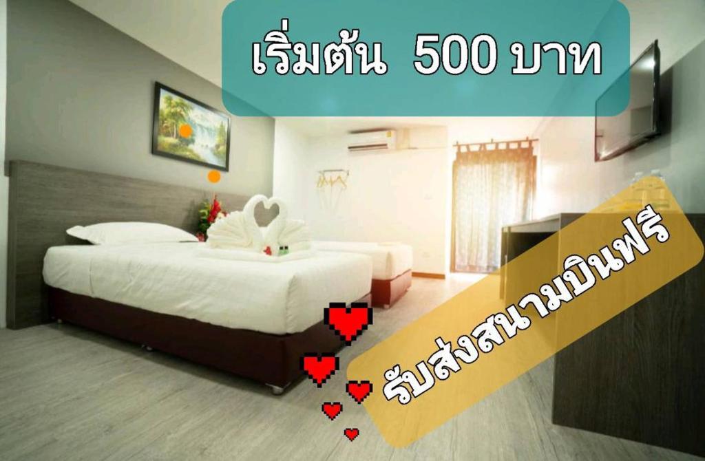 una habitación de hotel con 2 camas con corazones. en NK Residence Sakon Nakhon, en Sakon Nakhon