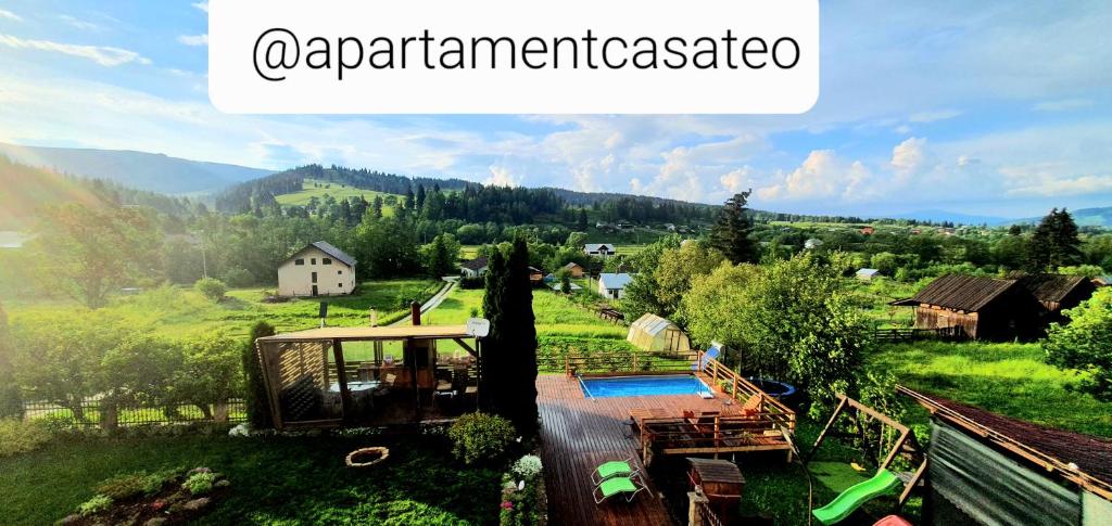 a view of a house in a green field with a house at Apartament Casa Teo in Şarul Dornei