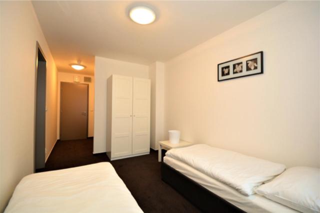 プラハにあるHotel Harfaのベッド2台とテーブルが備わる客室です。